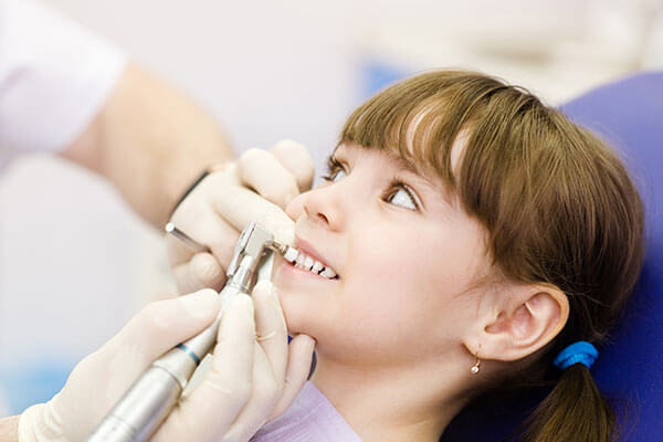 Professional cleaning of young girl's teeth