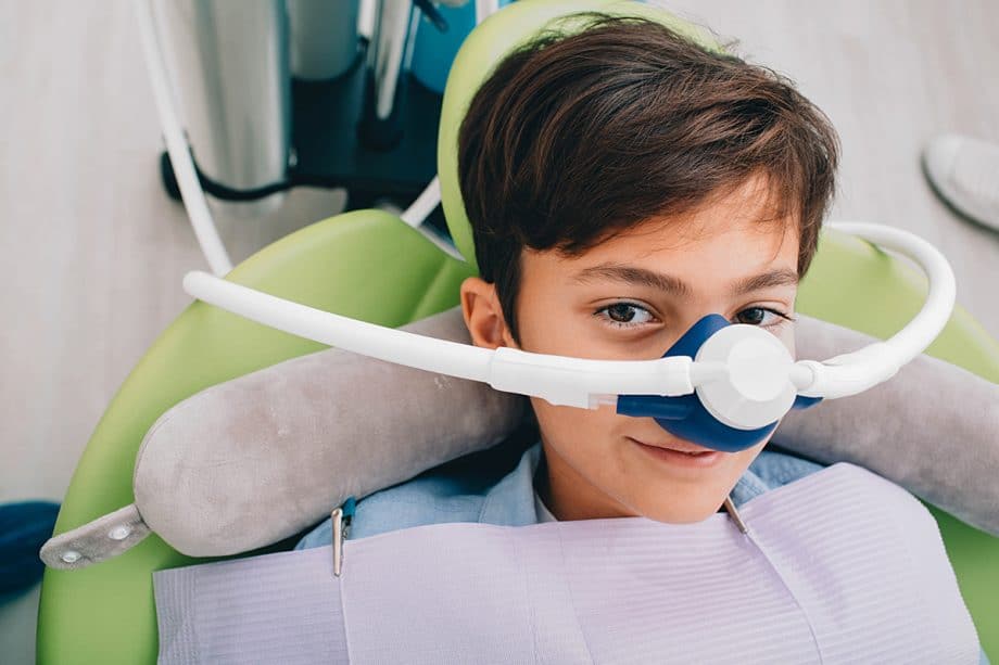 boy wears sedation respirator in dental chair